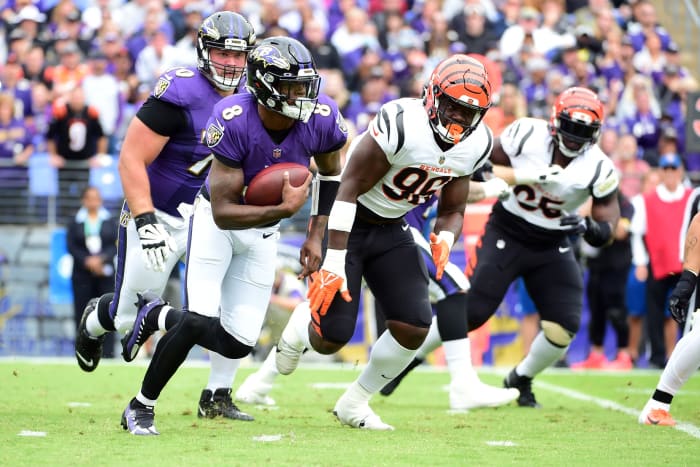 Oct 24, 2021; Baltimore, Maryland, USA; Baltimore Ravens quarterback Lamar Jackson (8) runs with the ball in front of Cincinnati Bengals defensive end Cam Sample (96) in the first quarter at M&T Bank Stadium. Mandatory Credit: Evan Habeeb-USA TODAY Sports